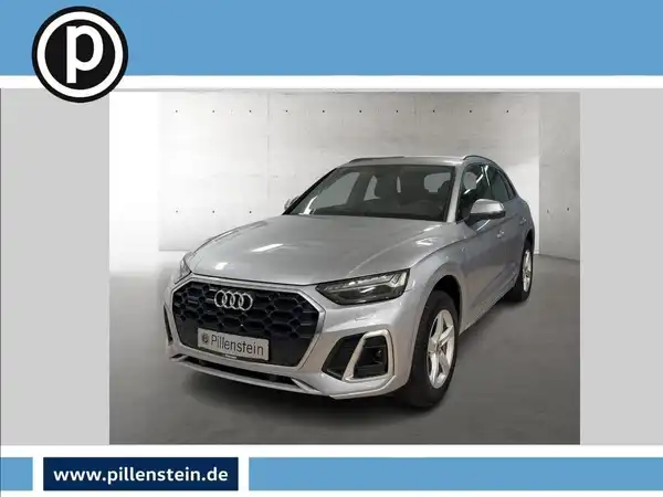 Das Bild zeigt einen silbernen Audi Q5 frontal aufgenommen. Im Hintergrund ist ein Händlertlogo sowie eine Website eingeblendet.