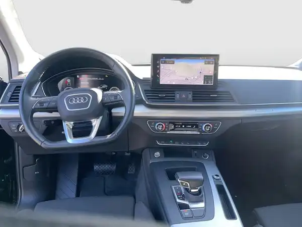 Das Bild zeigt das Innere eines Audi Q5. Es ist eine Aufnahme des Fahrzeuginnenraums mit einem schwarzen Interieur.