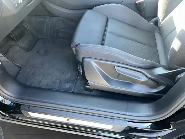Das Bild zeigt den Innenraum eines AUDI Q5, genauer gesagt den Fahrersitz in schwarzem Leder.