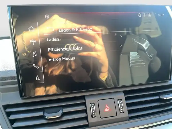 Das Bild zeigt das Innere eines Audis, insbesondere das Infotainment-Display mit einer Benutzeroberfläche für verschiedene Funktionen.