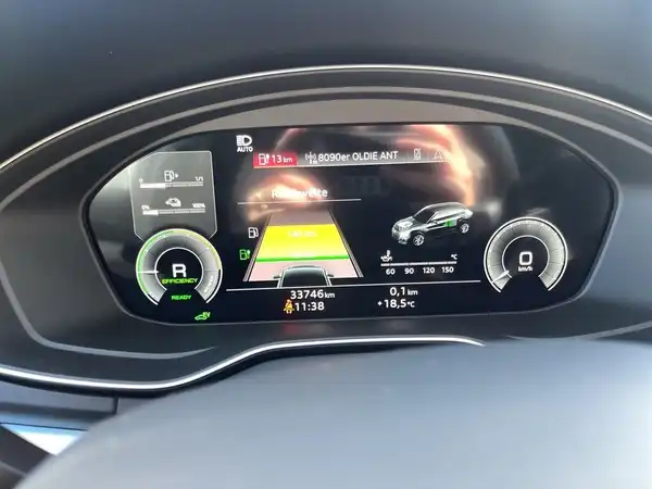Das Bild zeigt das Innenleben eines Fahrzeuges, genauer gesagt das Armaturenbrett eines Audi Q5 mit einem digitalen Display zur Fahrzeugnavigation.