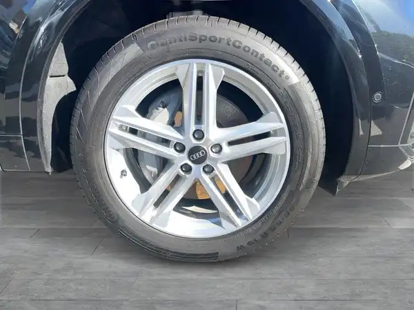 Das Bild zeigt die Seite eines schwarzen AUDI Q5 mit einem Fokus auf dem Rad und Reifen.