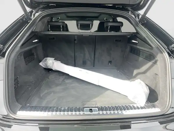Das Bild zeigt den Kofferraum eines schwarzen Audi Q8 von hinten.