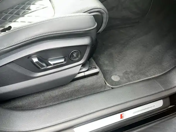 Innenaufnahme des Fahrzeugs zeigt den Fahrersitzbereich mit schwarzem Interieur.