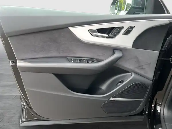 Das Bild zeigt die Innenseite einer Autotür eines schwarzen Fahrzeugs, mit einem grauen Interieur. Es handelt sich um eine Innenaufnahme.