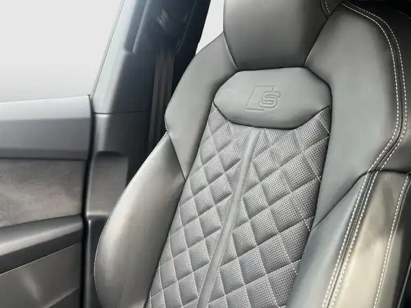Innenaufnahme eines Fahrzeugsitzes in Schwarz mit einem Rautenmuster.