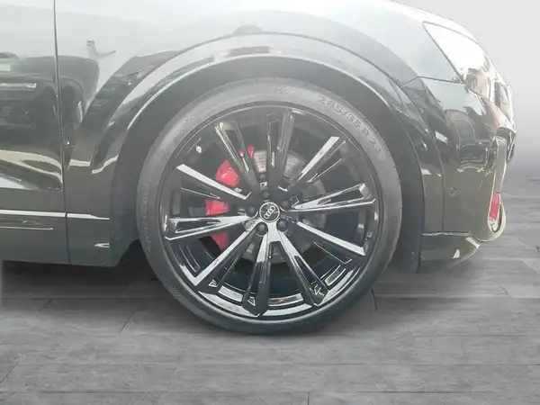 Das Bild zeigt die Seite eines schwarzen Audi Q8 mit einem Fokus auf dem Rad und der Felge.