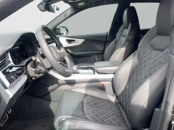 Das Bild zeigt den Innenraum eines AUDI Q8 mit schwarzen Ledersitzen und einem eleganten, modernen Design.