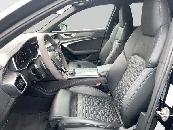 Das Bild zeigt das Innere eines Audi Quattro mit schwarzen Ledersitzen und einem modernen Armaturenbrett.