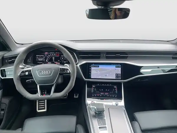 Das Bild zeigt das Innere eines Audi, aufgenommen aus der Innenansicht. Das Interieur ist schwarz und enthält markante Texteinblendungen.