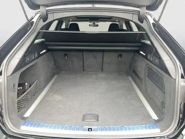 Das Bild zeigt den Kofferraum eines schwarzen AUDI QUATTRO aus der Rückansicht. Der Innenraum ist grau.