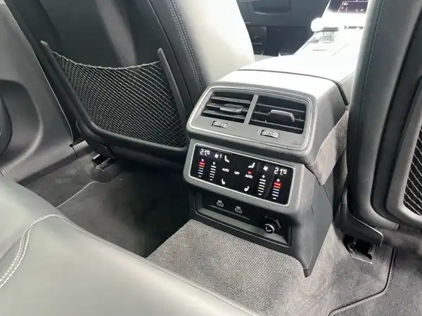 Das Bild zeigt den Innenraum eines Audi Quattro, aufgenommen aus der Innenansicht, mit einem Schwerpunkt auf der Mittelkonsole und Belüftungsanlagen, das Interieur ist schwarz.