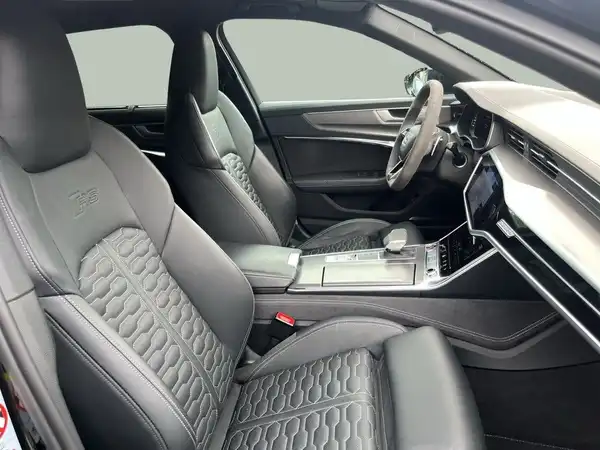 Das Bild zeigt den Innenraum eines Fahrzeugs, der hauptsächlich in schwarz gehalten ist. Die Sitze haben eine spezielle Struktur und das Armaturenbrett ist modern gestaltet.
