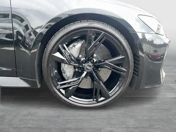 Das Bild zeigt die Seite eines AUDI QUATTRO mit einem Fokus auf dem Rad und der Felge. Das Fahrzeug hat eine graue Farbe.