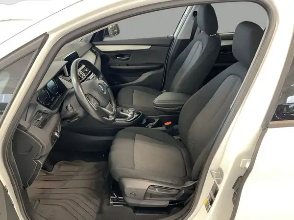 Das Bild zeigt das Innere eines BMW 225 in Schwarz mit komfortablen Sitzen und moderner Armatur.
