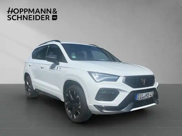 Das Bild zeigt einen weißen CUPRA ATECA von der Seite, mit dem Händlerinformationen oben links.