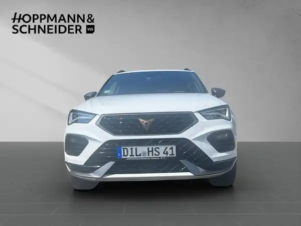 Das Bild zeigt einen weißen CUPRA ATECA aus der Frontalansicht, mit dem Händlerlogo HOPPMANN & SCHNEIDER im oberen Bereich.