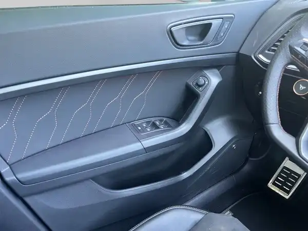 Das Bild zeigt das Innere eines CUPRA ATECA, aufgenommen von der Seitenansicht der Fahrertür. Die Innenfarbe ist schwarz mit kontrastierenden Nähten.