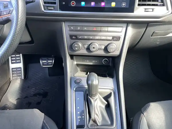 Innenaufnahme eines Fahrzeugs mit schwarzem Interieur und Bedienelementen.