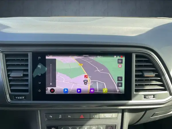 Das Bild zeigt den Innenraum des Fahrzeugs mit einem Navigationsbildschirm, der eine Karte anzeigt.