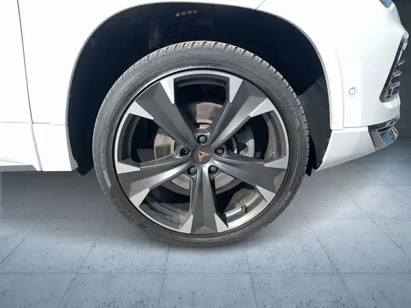 Das Bild zeigt die seitliche Ansicht des Radbereichs eines weißen CUPRA ATECA mit auffälligen Reifen und Felgen.