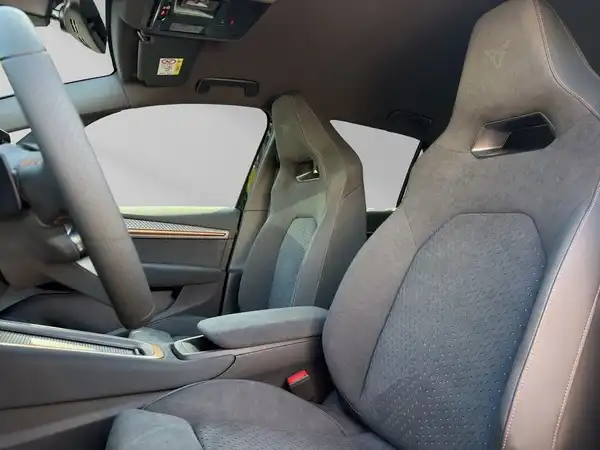 Das Bild zeigt den Innenraum eines Fahrzeugs aus einem Innenansicht mit schwarzen Sitzen und Armaturen.