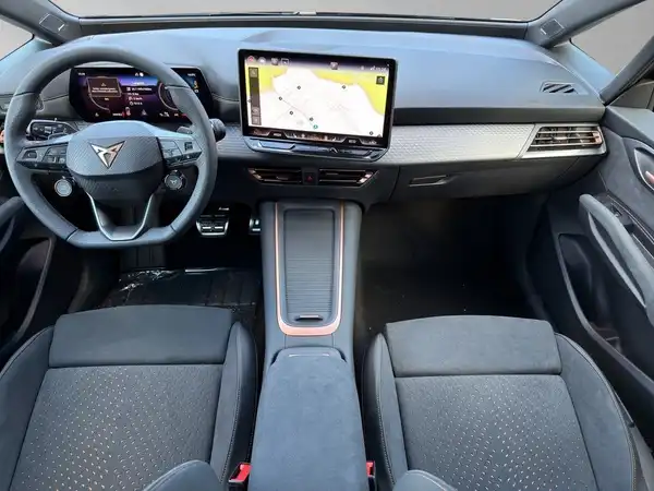 Dies ist eine Innenaufnahme des CUPRA BORN, mit schwarzem Interieur und modernem Armaturenbrett.