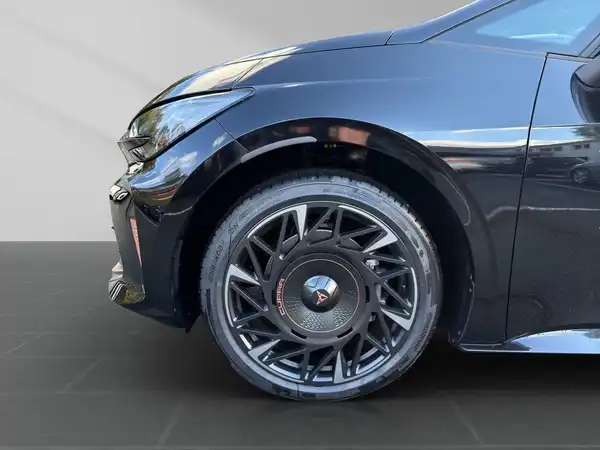 Seitliche Aufnahme eines schwarzen CUPRA BORN mit einem sportlichen Rad.