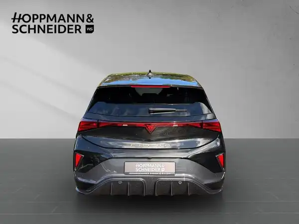 Das Bild zeigt einen CUPRA BORN in schwarzer Farbe, aufgenommen von hinten. Im Bild ist das Händlerlogo "HOPPMANN & SCHNEIDER" prominent platziert.