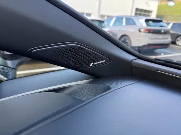 Das Bild zeigt eine Innenaufnahme des CUPRA BORN, mit einem schwarzen Innenraum und einem Lautsprecher. Es sind keine Händlerlogos sichtbar, aber es gibt markante Texteinblendungen.