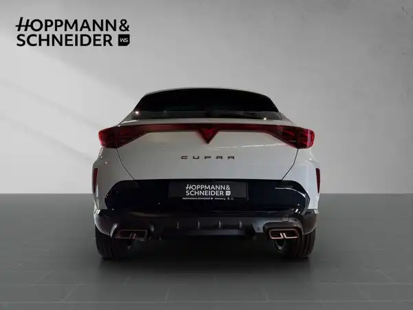 Das Bild zeigt einen CUPRA FORMENTOR von hinten in weißer Farbe. Im oberen Bereich ist ein Händlerlogo sichtbar, zusammen mit markanten Texteinblendungen.