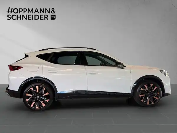 Das Bild zeigt einen CUPRA FORMENTOR von der Seite in weißer Farbe. Im Hintergrund ist das Händlerlogo "HOPPMANN & SCHNEIDER" sichtbar.