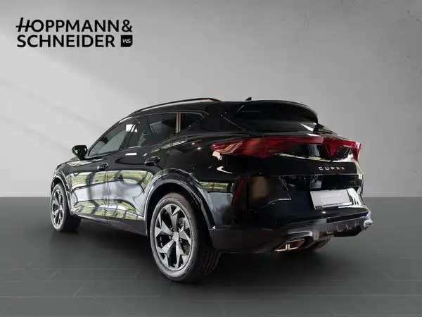 Das Bild zeigt ein schwarz lackiertes Fahrzeug, einen CUPRA FORMENTOR, von der Seite. Im Hintergrund ist das Händlerinlogo 'HOPPMANN & SCHNEIDER' eingeblendet.