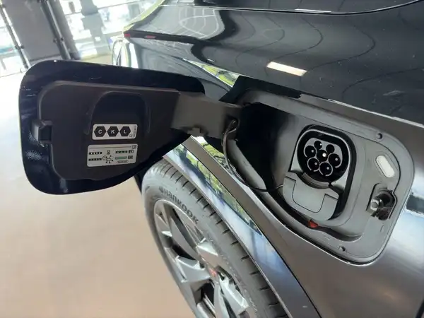 Auf dem Bild ist der obere Bereich eines CUPRA FORMENTOR von der Seite zu sehen, einschließlich der Ladeanschlussabdeckung, schwarz lackiert.