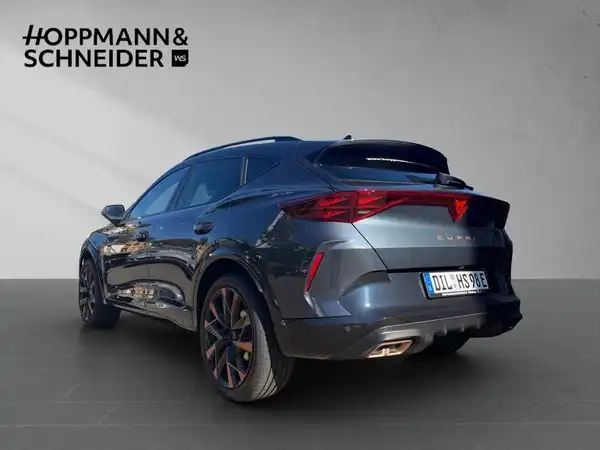 Das Bild zeigt einen CUPRA FORMENTOR aus der Rückansicht in grauer Farbe mit sichtbarem Händlerlogo und markanten Texteinblendungen.