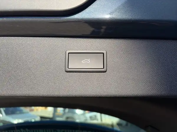 Das Bild zeigt das Innere eines Fahrzeugs, genauer gesagt einen schwarzen Teil des Armaturenbretts mit einem Schalter.