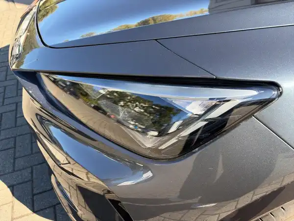 Das Bild zeigt die Vorderansicht eines grauen CUPRA FORMENTOR mit einem Fokus auf dem Scheinwerfer.
