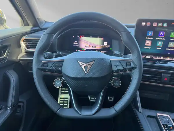 Das Bild zeigt das Interieur eines CUPRA FORMENTOR mit einem schwarzen Lenkrad und einem modernen Armaturenbrett.