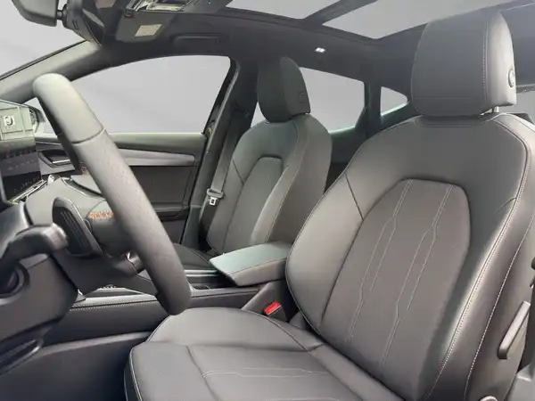 Das Bild zeigt den Innenraum eines Fahrzeugs, insbesondere die vorderen Sitze in schwarzem Leder mit einem modernen Dashboard.