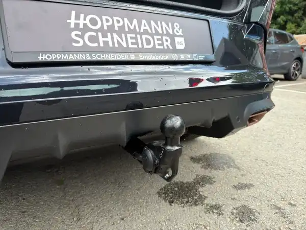 Das Bild zeigt einen schwarzen CUPRA FORMENTOR aus der Rückansicht. Der Fahrzeughaken ist deutlich sichtbar, und das Händlerschild 'HOPPMANN & SCHNEIDER' ist eingeblendet.