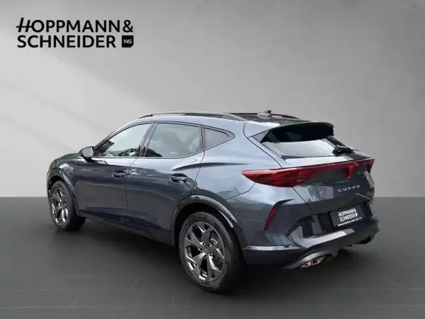 Das Bild zeigt einen CUPRA FORMENTOR von der Seite in grau, mit dem Händlermarkenlogo HOPPMANN & SCHNEIDER im oberen linken Bereich.