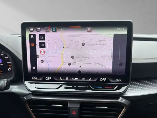 Das Bild zeigt das Innere eines Fahrzeugs, insbesondere den Infotainment-Bildschirm, der eine Navigationskarte anzeigt. Die Innenfarbe ist schwarz.