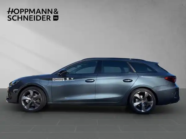 Das Bild zeigt einen CUPRA LEON SPORTSTOURER von der Seite in grauer Farbe. Auf dem Bild ist das Händlerlogo von HOPPMANN & SCHNEIDER zu sehen.