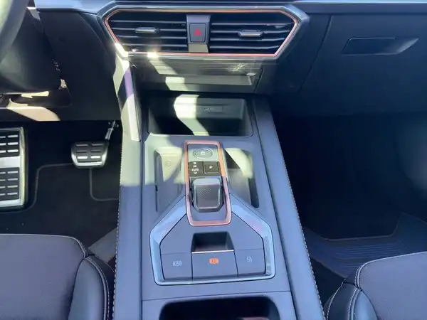 Das Bild zeigt den Innenraum eines CUPRA LEON SPORTSTOURER aus der Vogelperspektive, mit einem zentralen Bedienfeld und einem modernen schwarz-grauen Interieur.