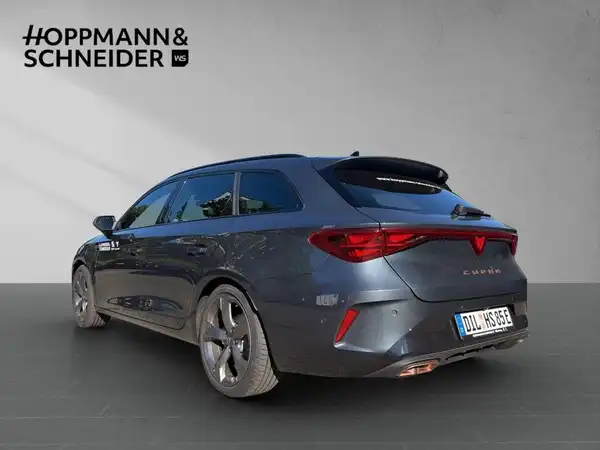 Das Bild zeigt einen grau lackierten CUPRA LEON SPORTSTOURER von der Seite, mit dem Händelernlogo "HOPPMANN & SCHNEIDER" im oberen Bereich.