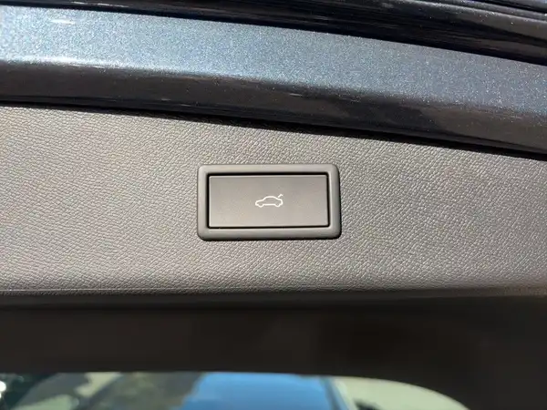 Innenaufnahme des CUPRA LEON SPORTSTOURER, zeigt den Knopf zum Öffnen des Kofferraums. Das Interieur ist in Schwarz. Keine sichtbaren Händlerlogos oder markante Texteinblendungen.