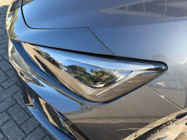 Das Bild zeigt die Frontansicht des CUPRA LEON SPORTSTOURER in grau, mit einem Fokus auf das Scheinwerferdesign.