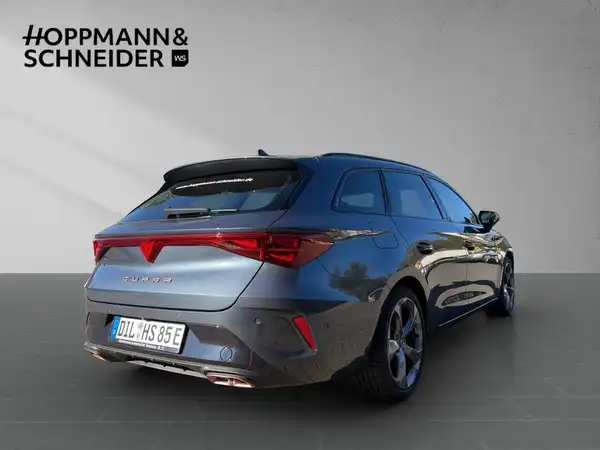 Das Bild zeigt einen CUPRA LEON SPORTSTOURER von hinten in grauer Farbe. Es ist ein Fahrzeugbild mit einem Händlerlogo und enthält keine auffälligen Texteinblendungen.