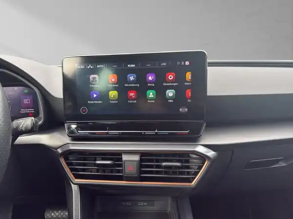 Das Bild zeigt den Innenraum eines CUPRA LEON mit einem Blick auf das Infotainment-Display. Das Interieur ist schwarz.