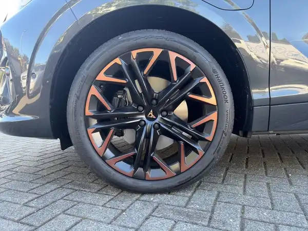 Das Bild zeigt eine seitliche Ansicht eines Fahrzeugs mit einem schwarzen Rad und einer Kombination aus schwarzen und orangen Felgen.